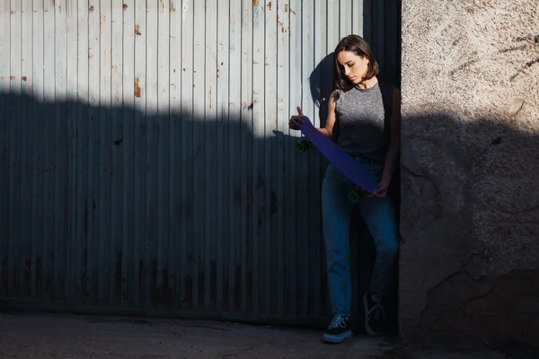 Jeune femme avec skateboard bleu penny dans un port décontracté — Photo