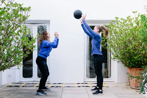 Deux jeunes femmes faisant de l'exercice avec le ballon de médecine — Photo