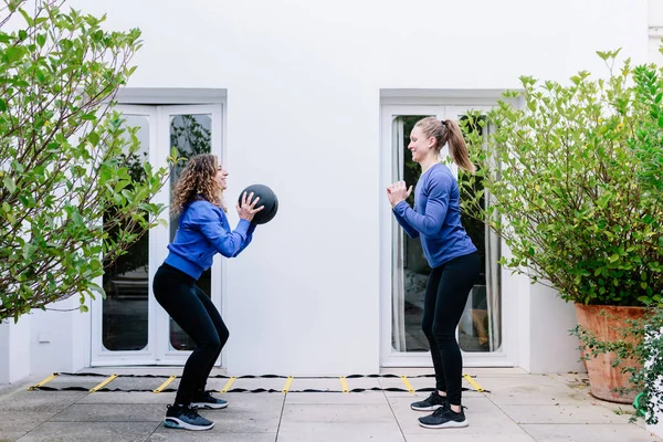 Two young women doing exercise together with medicine ball — Stok fotoğraf