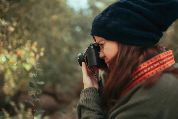 Genç bir kadın ormanda eski bir kamerayla fotoğraf çekiyor. — Stok fotoğraf