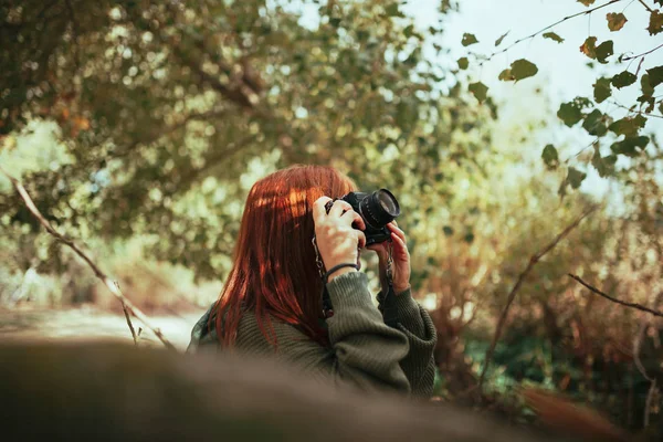 Genç bir kadın ormanda eski bir kamerayla fotoğraf çekiyor. — Stok fotoğraf