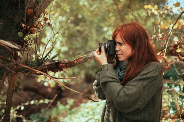 Young woman taking photos in the forest with an old camera — Stock Photo, Image