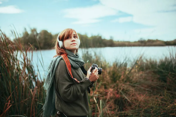 年轻女子拿着旧相机在森林里拍照 — 图库照片