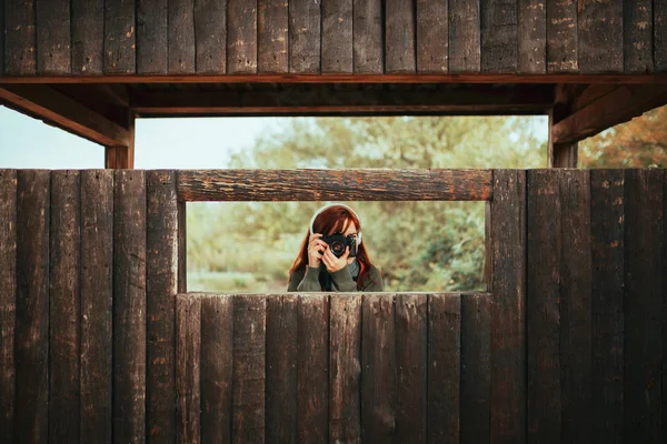 Jonge vrouw maakt foto 's van houten hut in het bos — Stockfoto