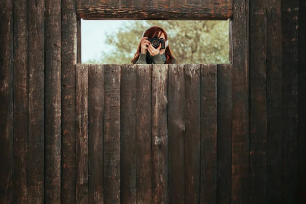 年轻女子在森林的木棚屋拍照 — 图库照片