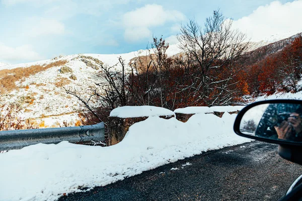 Мужчина Фотографирует Своей Машины Снежную Гору Отражением Зеркале Автомобиля — стоковое фото