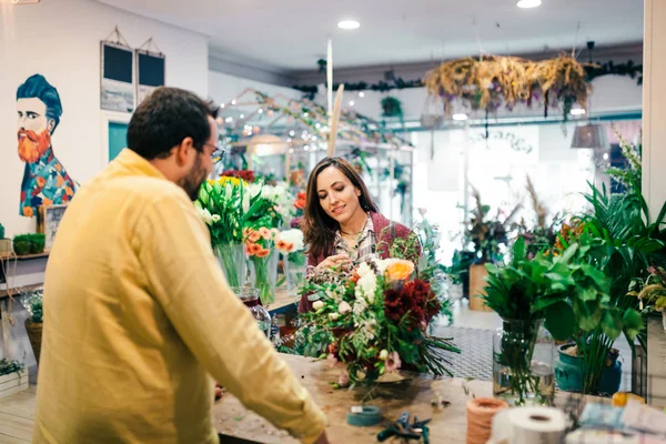 Giovane donna che compra un mazzo di fiori in un fiorista — Foto Stock