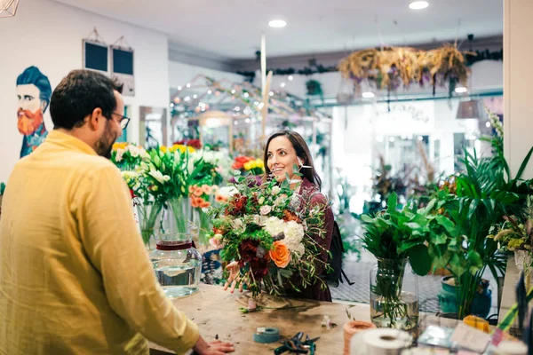 Jeune femme achetant un bouquet de fleurs dans un fleuriste — Photo