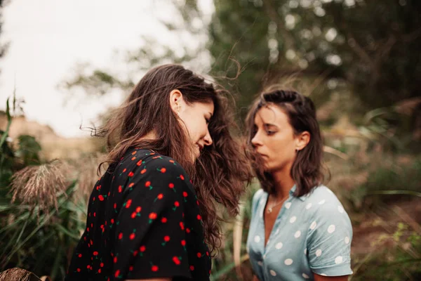 Due giovani donne si guardano con il vento tra i capelli — Foto Stock