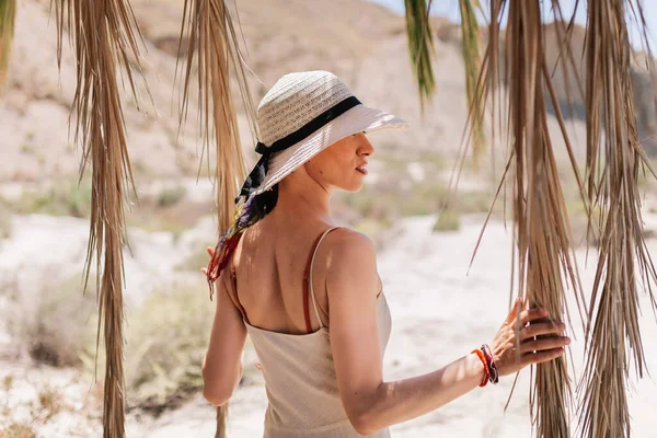 Mujer vestida de pie cerca de la palmera en el desierto —  Fotos de Stock
