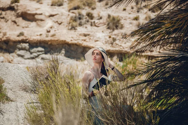 Mulher lendo um livro vestindo vestido assentos perto de palmeira — Fotografia de Stock