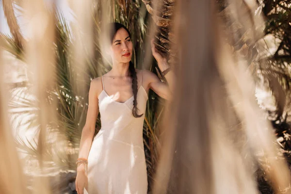 Frau mit Kleid steht in der Nähe einer Palme in der Wüste — Stockfoto