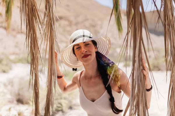 Mujer vestida de pie cerca de la palmera en el desierto —  Fotos de Stock