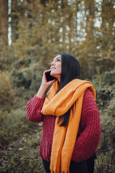 Ormanda akıllı telefonuyla konuşan genç bir kadın. — Stok fotoğraf