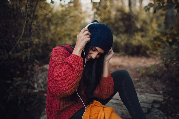 Giovane donna che ascolta musica con le cuffie nella foresta — Foto Stock