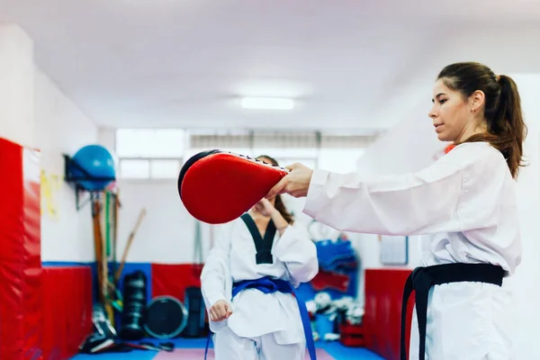 Two young women practice taekwondo in a training center — Stock Photo, Image