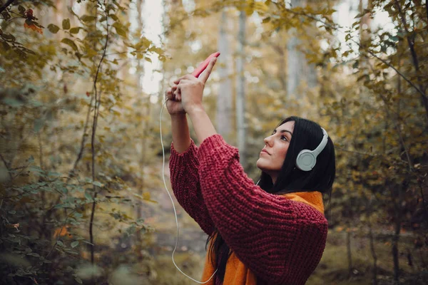 Femme prenant un selfie avec son téléphone avec des écouteurs — Photo