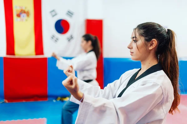 Dwie młode kobiety ćwiczą taekwondo w ośrodku treningowym — Zdjęcie stockowe