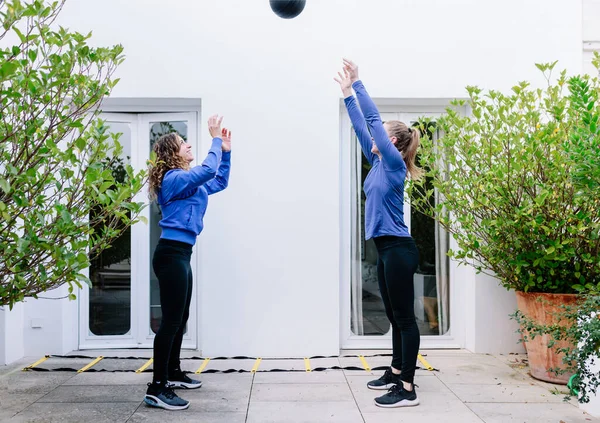 Duas mulheres jovens fazendo exercício em conjunto com a bola de medicina — Fotografia de Stock