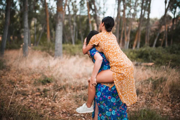 Mulher Piggybacking Feliz Namorada Enquanto Desfruta Floresta — Fotografia de Stock