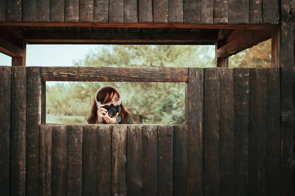 年轻女子在森林的木棚屋拍照 — 图库照片
