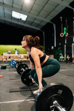 Güçlü kadın halterci spor salonunda kaldırmaya hazırlanıyor..