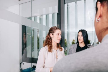 Bir grup ofis çalışanı patronun etrafında toplanıyor.