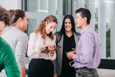 Bir grup ofis çalışanı patronun etrafında toplanıyor.