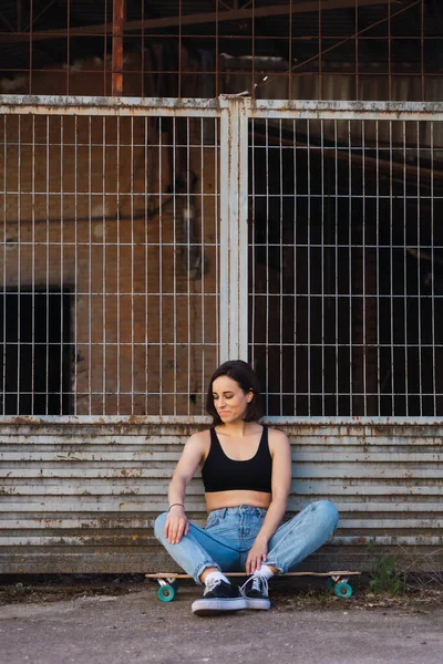 Jovem Mulher Sentada Seu Skate Uma Rua Industrial Velha — Fotografia de Stock