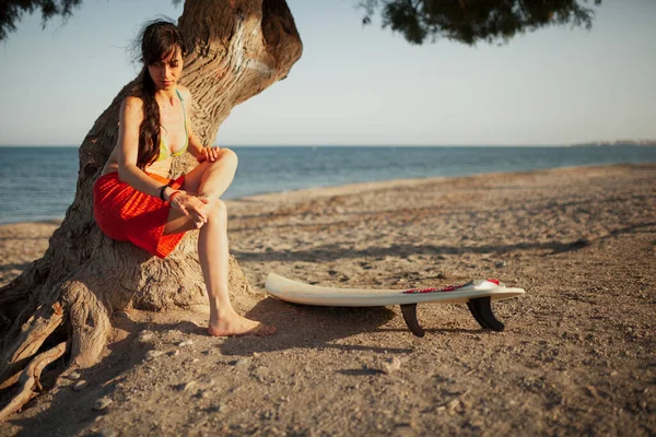 海滩上的年轻女子 她的冲浪桌在沙滩上等着 — 图库照片