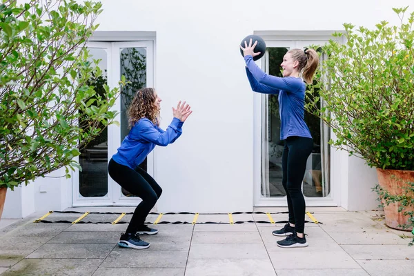 Две Молодые Женщины Делают Упражнения Вместе Мячом Террасе — стоковое фото