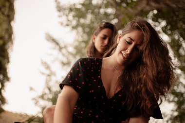 Sahada birbirine sarılan iki genç lezbiyen kadın.