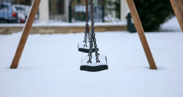 Wooden swing covered with snow — Stock Photo, Image