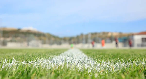 Closeup of painted boundary line of a green football field.