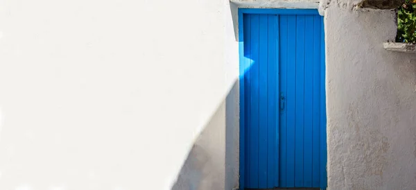 Griechenland, kea island. blaue Holztür auf weißem Wandhintergrund — Stockfoto