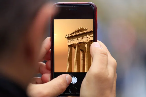 Parthenon in Athene foto wordt weergegeven op tablet, smartphone in iemands handen. Onscherpe achtergrond — Stockfoto