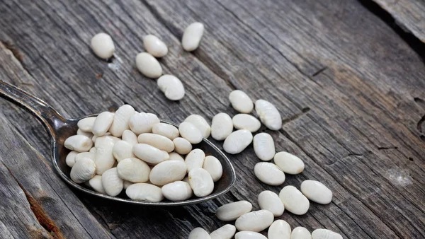 White haricot beans on an old wooden table — Stock Photo, Image