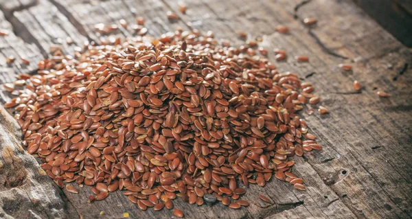 Heap of flax seeds, on wooden surface. — Stock Photo, Image