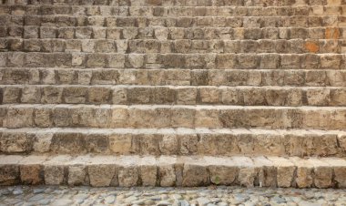 Merdiven yaşlı, taşlarla yapılan yıpranmış. Taş arka plan boş, görünümü ayrıntıları ile kadar yakın.