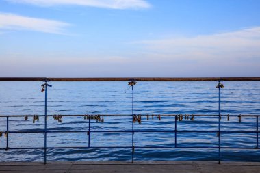 Paslı kilit platformu soyulmuş bir korkuluk Tarih kilitli. Mavi gökyüzü ve denizin arka plan.