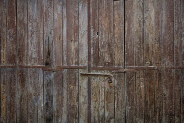 Ahşap kahverengi kapı, paslı mandal ve asma kilit yaşlı. Yakın, detayları — Stok fotoğraf