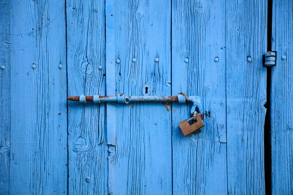 Дерев'яні яскраво-блакитні, порожні, старі двері для фону. Іржава засувка, замок. Крупним планом, банер, деталі — стокове фото