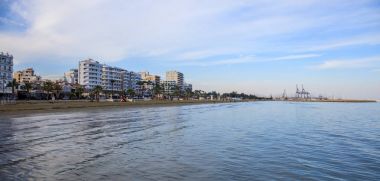 Finikoudes beach, Kıbrıs. Mavi gökyüzü ve bulutlar üzerinde şehir Larnaka arka plan için. Alan, afiş
