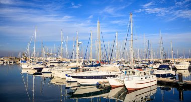 Larnaka ev sahibi Marina deniz araçları, Kıbrıs palamarla. Tekneler, mavi gökyüzü bulutlar arka plan yansıması.