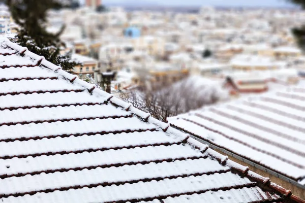 Snötäckta hustak. Vinter, tid för semester på en stad i frost. Sudda bakgrund, närbild, detalj — Stockfoto