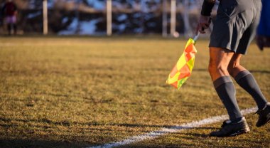 Futbol hakem Yardımcısı sideline elinde bayrakla taşır. Yeşil alan, doğa zemin bulanıklık, yakın görünümü, afiş, alan..
