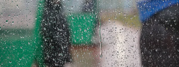 Dešťové kapky na průhledné okno. Abstraktní, rozmazané pozadí, zblízka pohled, banner, prostor pro text. — Stock fotografie