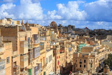 Malta Valletta. Sermaye uzun geleneksel kireçtaşı binalar, az bulutlu ile mavi gökyüzü altında.