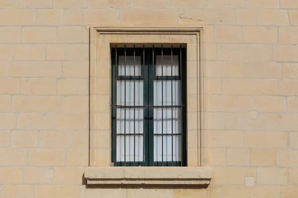 Malta Valletta. Cephe sarı kireçtaşı evin metal çubuklarla kapalı pencere ile bu güvenlik sağlar. Görünümü kapatın. — Stok fotoğraf