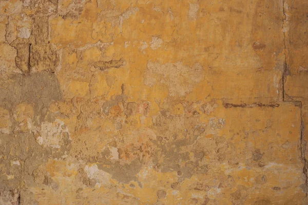 Fondo de pared pintado amarillo envejecido, parcialmente descolorido — Foto de Stock